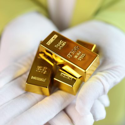 Close-up,Of,Man,Holding,Gold,Bars,In,His,Hands.,Several
